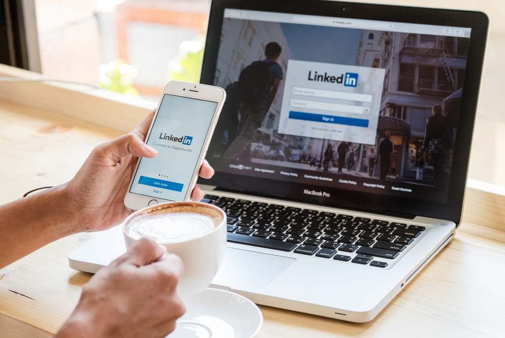 man-browsing-linkedin-on-laptop-and-mobile